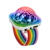 Close up of a sound activated party light watch casting a vibrant neon glow over a dark background.